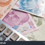Stock photo calculator standing on and turkish lira or tl banknotes